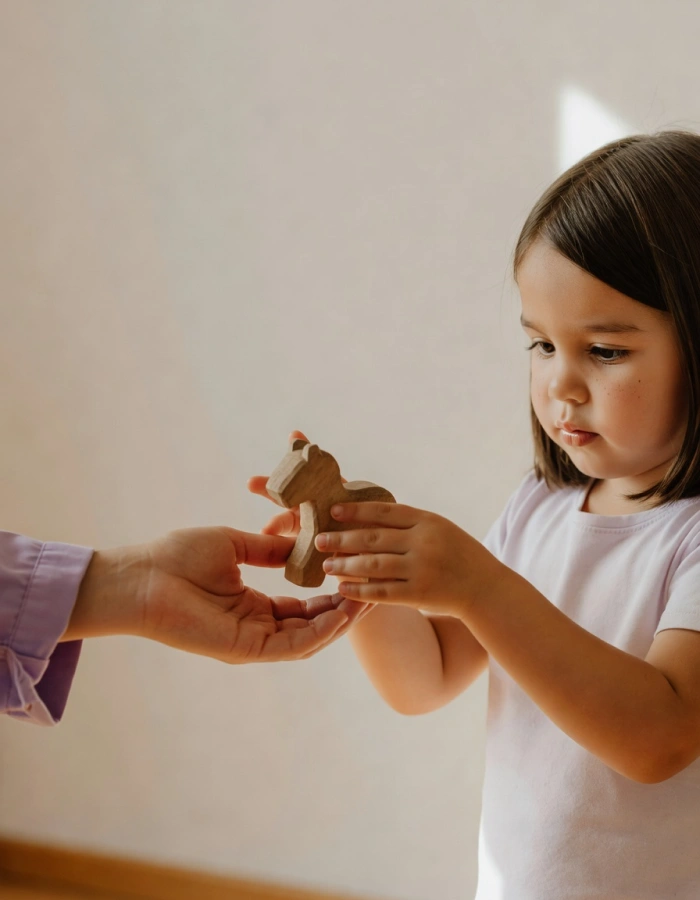 Niña entregando un objeto a la terapeuta en sesión de terapia ocupacional — Mimos Desarrollo Integral, Sada, A Coruña
